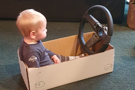 Children have such imaginations - here a boy sits in a box with a steering wheel - an instant car!